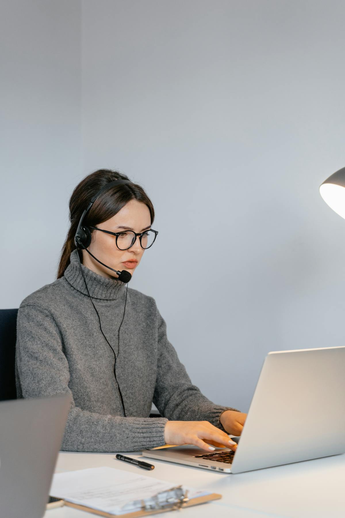 Agente de soporte trabajando con auriculares frente a una laptop