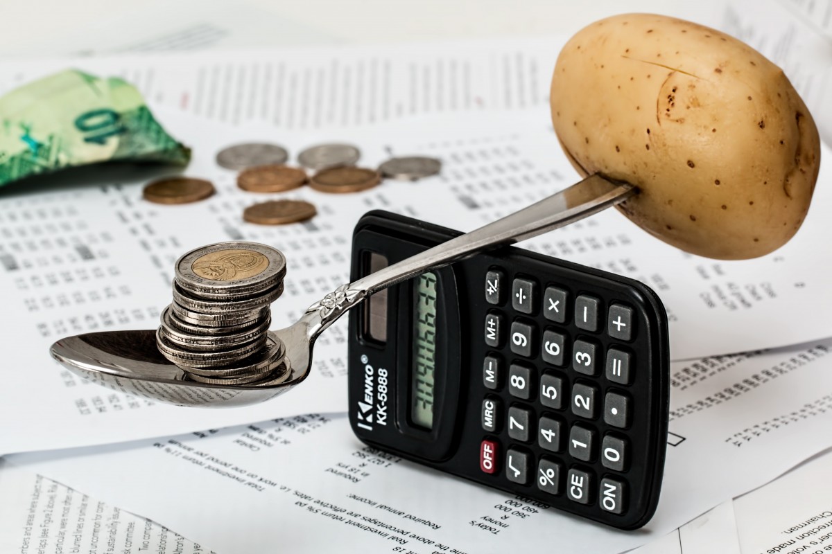 Calculadora, monedas y notas de presupuesto sobre una mesa