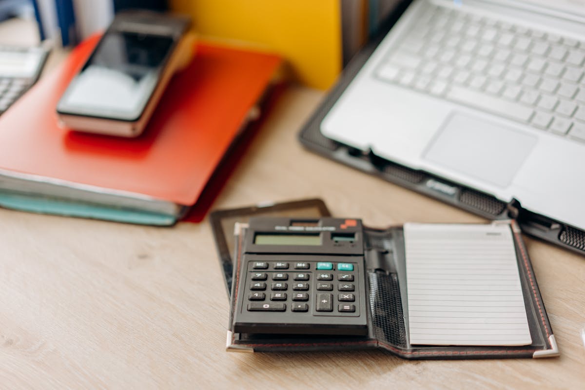 Calculadora y billetera sobre una mesa de trabajo