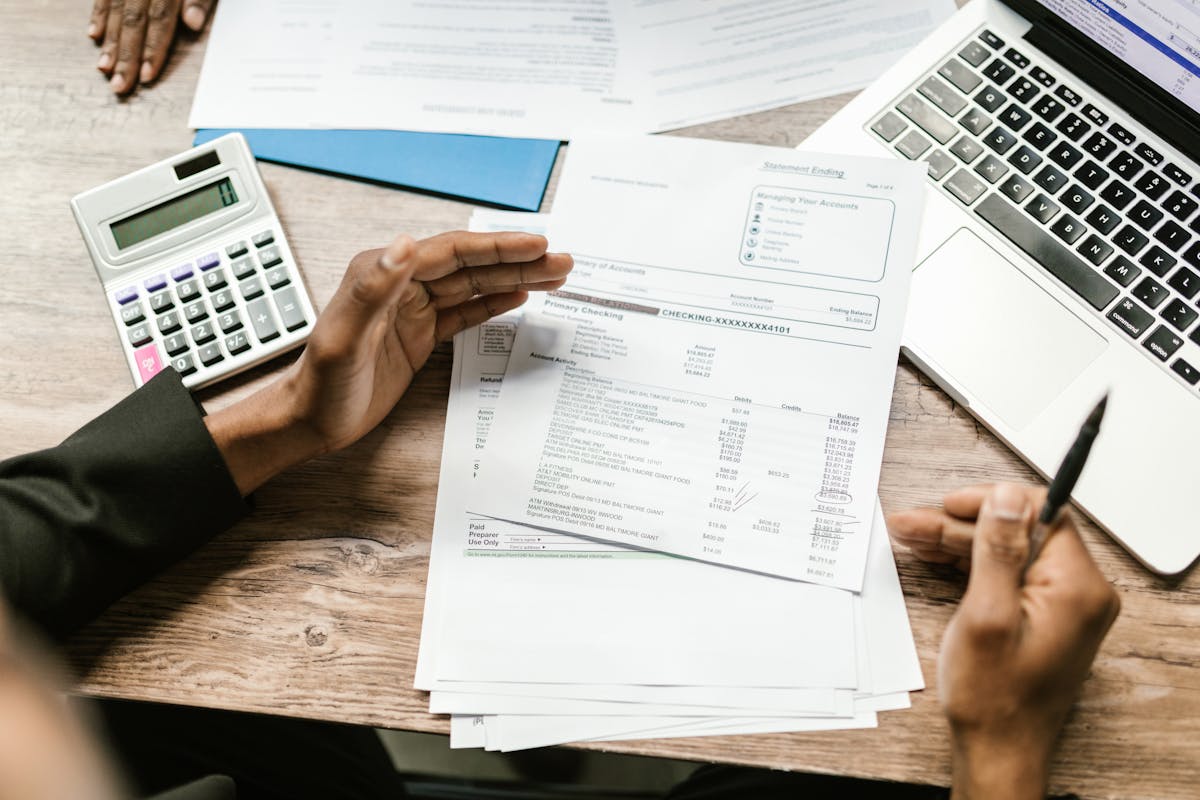 Persona revisando estados de cuenta y papeles con otra persona